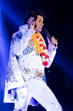 Sylvain Leduc performing an Aloha‑themed Elvis tribute in Hawaiian‑style attire.