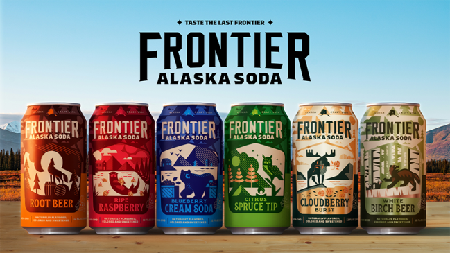 Six cans of Frontier Alaska Soda—White Birch Beer, Cloudberry Burst, Citrus Spruce Tip, Ripe Raspberry, Blueberry Cream Soda, and Aurora Borealis—arranged on a rustic wooden surface with an Alaskan mountain landscape in the background.